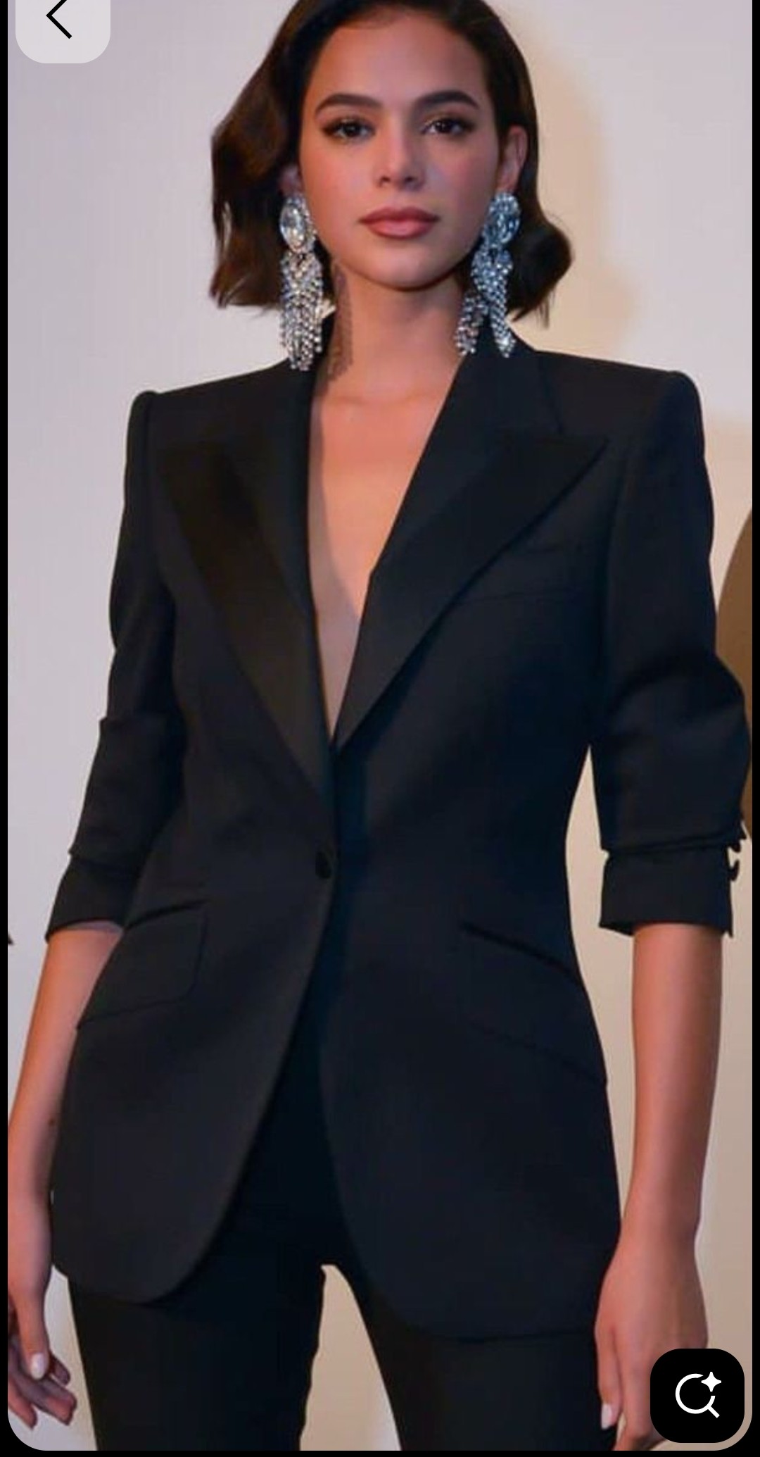 Lady dressed in classic sexy black pant suit .